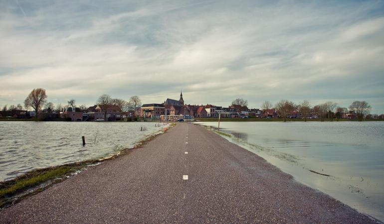 Foto van een weg in Nederland omringt door water 