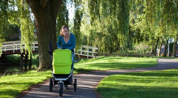 vrouw in park met kinderwagen