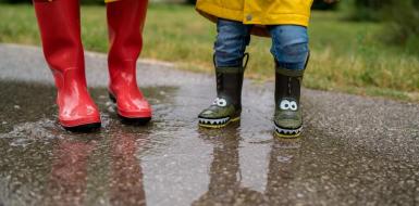 kids met regenlaarsjes in een waterplas kids met regenlaarsjes in een waterplas